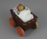 Hölzerner Kinderwagen mit Baby und Püppchen im blauen Kleid