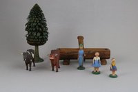 Hölzernes Spielzeug mit zwei Kühen, zwei Mädchen, einem Hirten, einem Brunnen und einem Baum