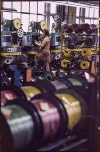 Kabelwerk Oberspree (KWO), Bild 5: Mitarbeiterin in der Kabelproduktion. Farbfoto, 1970er Jahre © Kurt Schwarz.