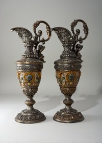 Zwei Kerzenhalter in Form von Metallkrügen
