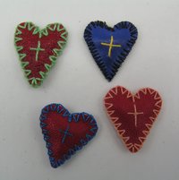 Vier amulettartige Herzen aus Leder/Kunstleder mit eingenähten kleinen Wachspäckchen