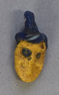 Gelber Maskenanhänger aus Glas mit blauem Haar