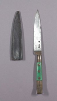 Ein Vorlegemesser mit grünem Heft und Messingbeschlägen