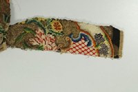 Stickfragment mit stilisierten Blütenzweigen und Volutenmotiven