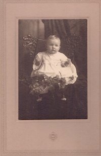 Foto eines kleinen Kindes im weißen Spitzenkleid