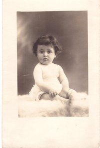 Foto kleines Kind auf einem Fell sitzend.