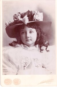 Foto eines kleinen Mädchens mit Blumen am Hut