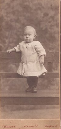 Foto Kleinkind auf einer Bank stehend