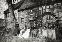 Junge Frau steht neben dem Mühlrad der Bodendorfer Mühle