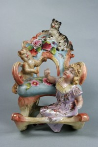 Figurengruppe: Ein Mädchen mit zwei Katzen auf Schaukelstuhl